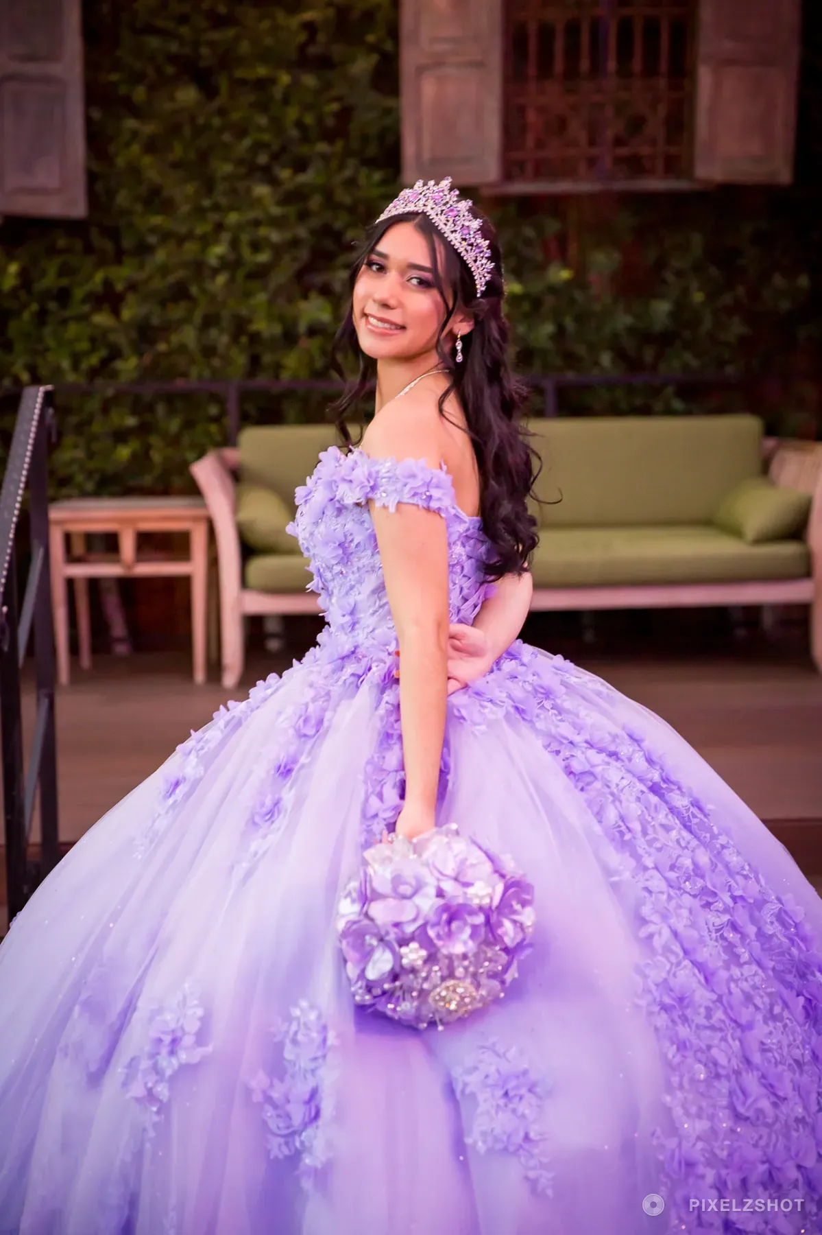 Jasmine looking back over her shoulder with a smile, the jeweled lilac bouquet held at her side