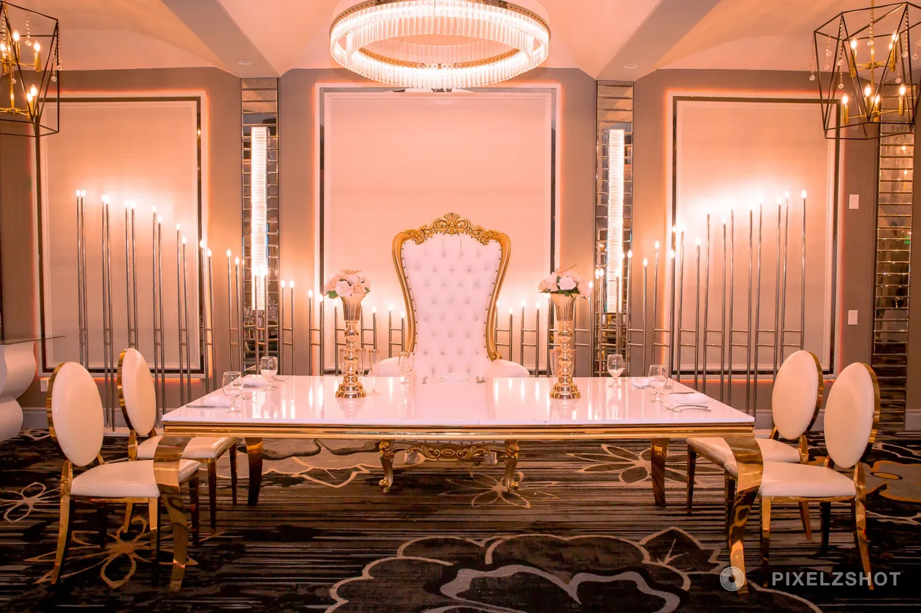 The head table at Etage Venue set in white and gold, a tufted throne chair at its centre under a ring chandelier