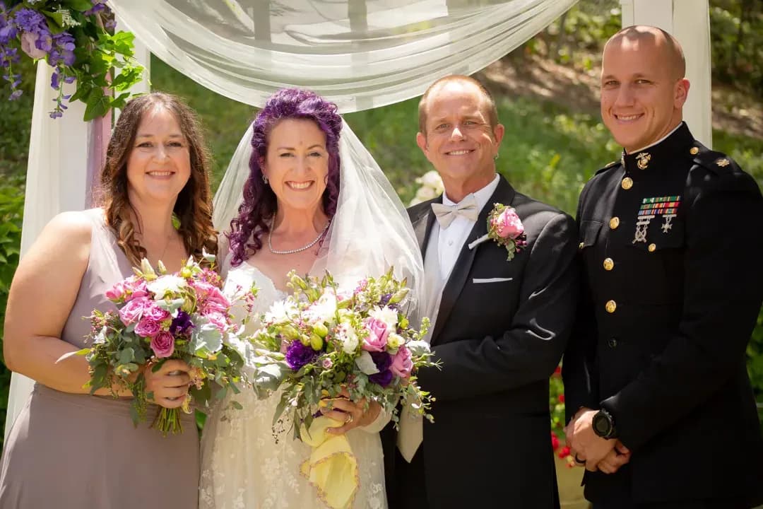 Bride and groom posing with family under the ceremony arbor in Topanga Canyon